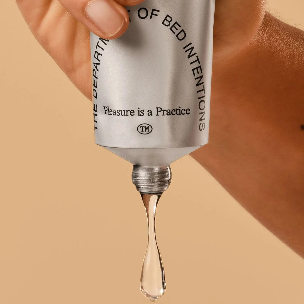Skincare serum dropper with 'The Department of Bed Intentions' branding on a beige background