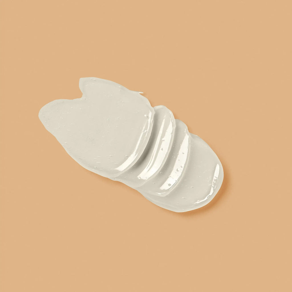 A translucent, semi-opaque white silicone or rubber pad with a wavy, layered shape, displayed on a solid warm beige background.