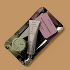Set of personal care products on a reflective surface with a beige background