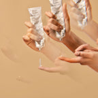 Hands holding and using water-based lubricant on a beige background