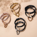 Set of leather bracelets with chain accents on a beige background