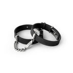 Two black rubber bracelets with silver chains on a white background