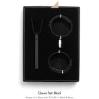 Black jewelry set with 'Vesper 2' and 'ID Cuffs' in a black box on a white background.
