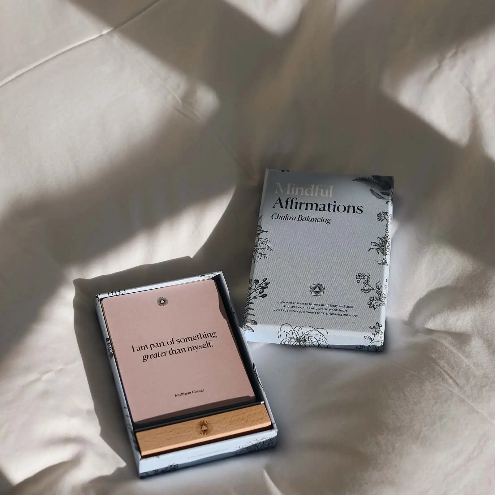 Two books on a textured surface with soft shadows