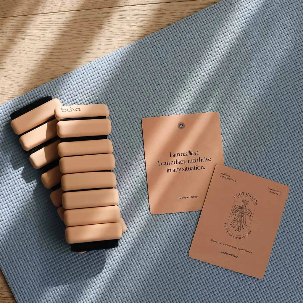 Set of yoga blocks and two cards on a textured mat with wooden floor background