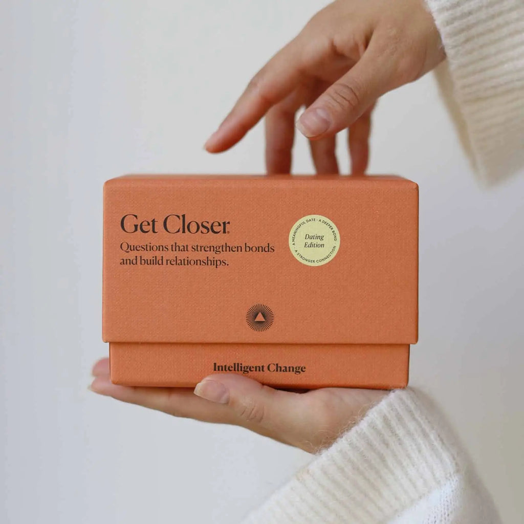 Person holding an orange box with text on a light background