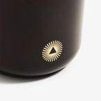 Black mug with a gold logo on a white background