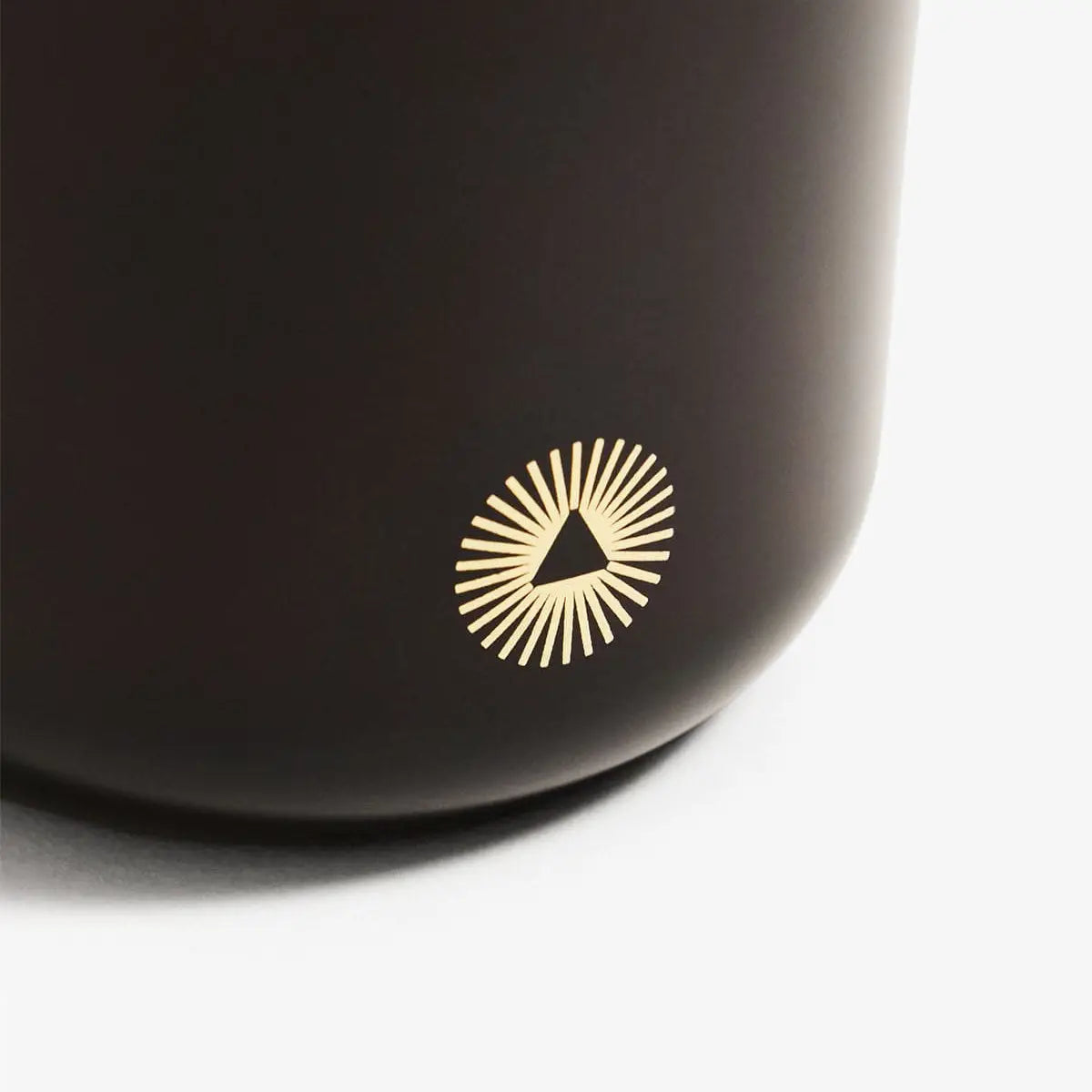 Black mug with a gold logo on a white background