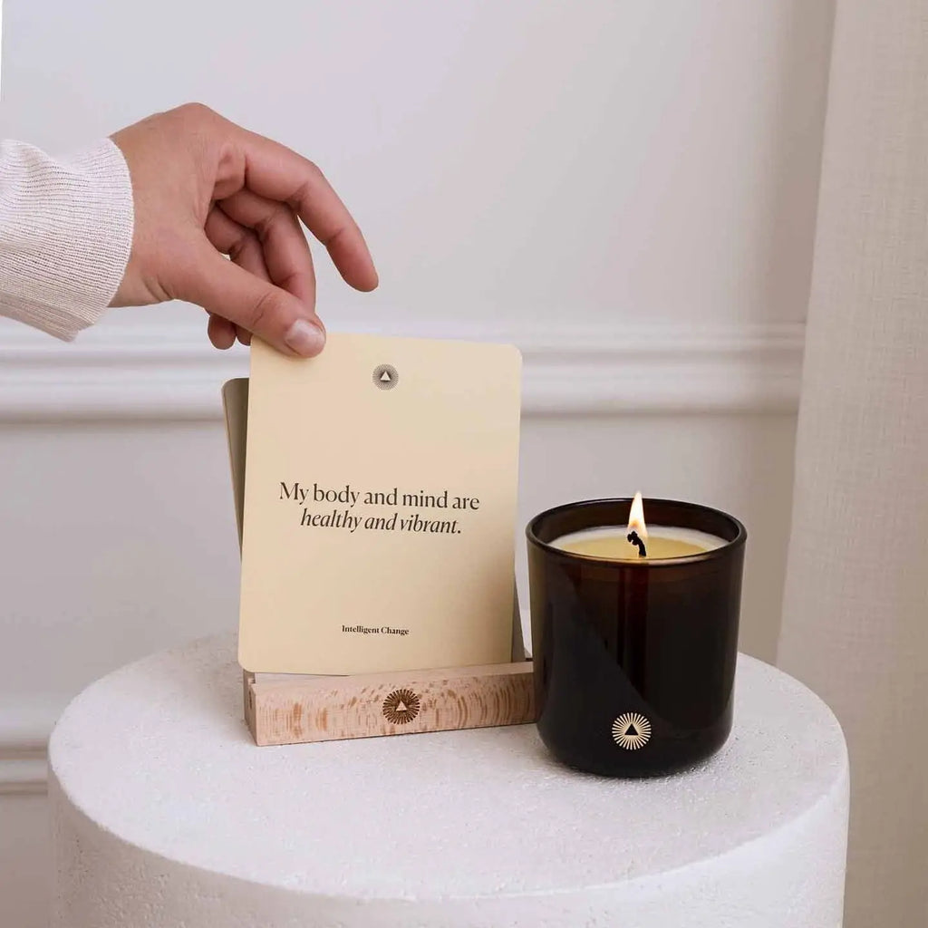Candle and card on a white surface with a neutral background