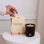 Candle and card on a white surface with a neutral background