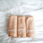 Three folded beige towels with 'OFFDENTIST' branding on a white background