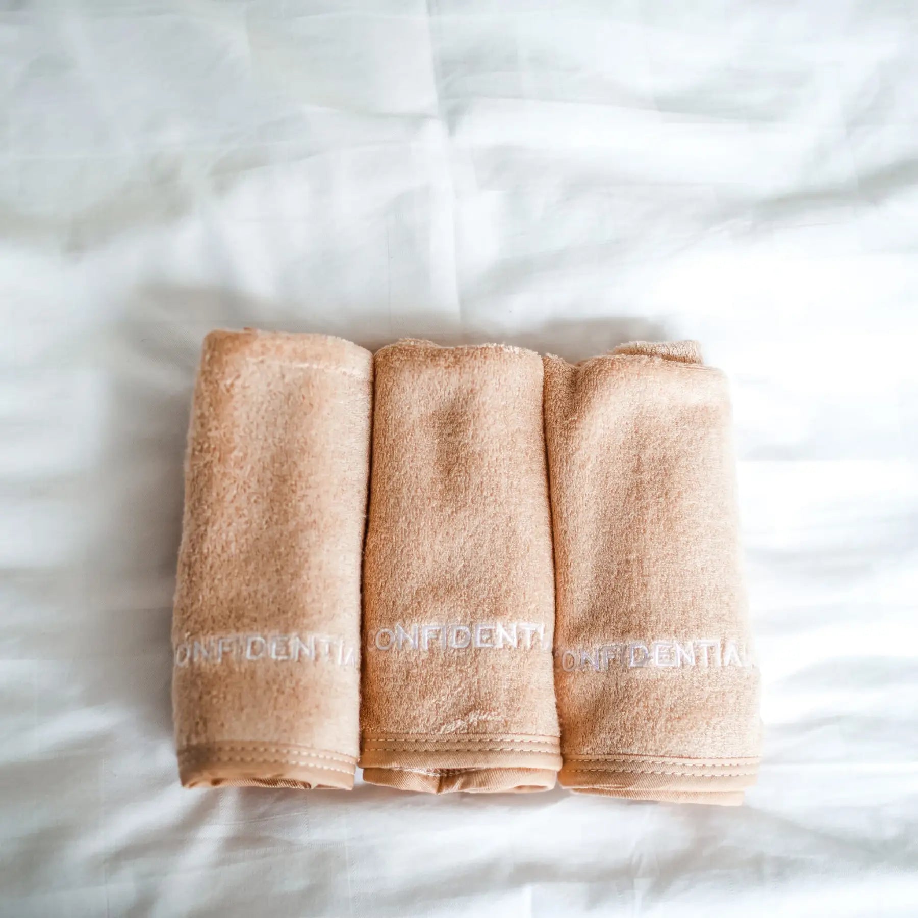 Three folded beige towels with 'OFFDENTIST' branding on a white background