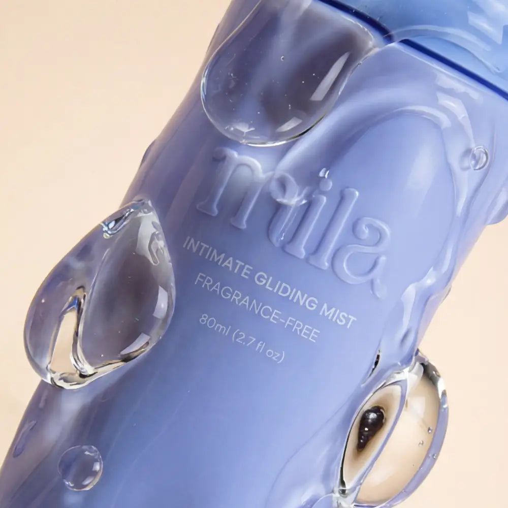 Blue bottle of Nila intimate gliding mist on a beige background