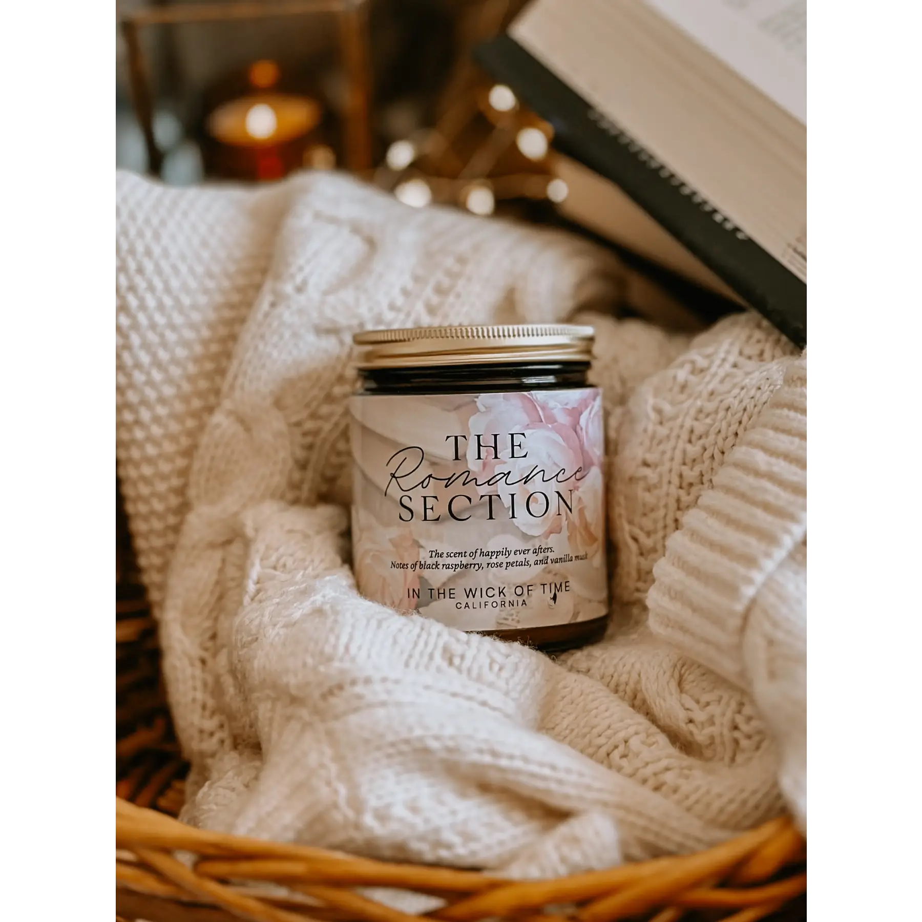Candle labeled 'The Romance Section' in a basket with soft textures and warm tones