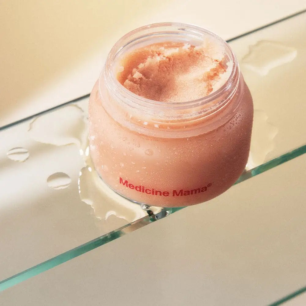 Jar of pink cream labeled 'Medicine Mama' on a glass surface.