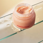 Jar of pink cream labeled 'Medicine Mama' on a glass surface.